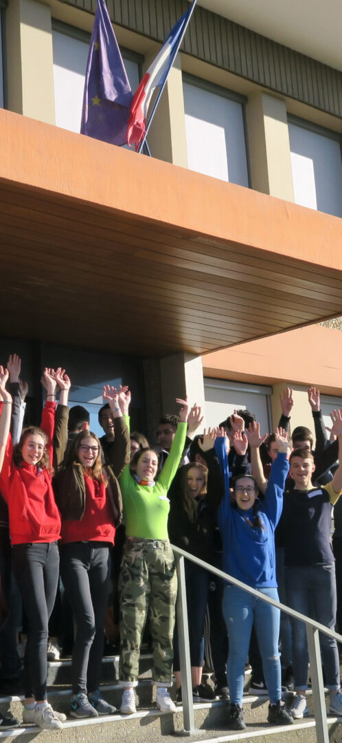 Des élèves les bras en l'air devant l'entrée du lycée à une journée porte-ouverte.