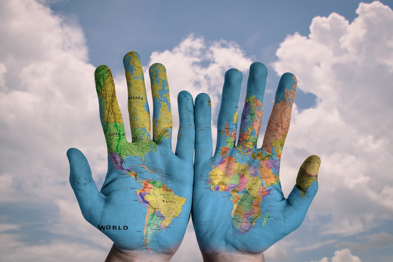 La carte du monde peinte sur deux mais paumes vers nous.